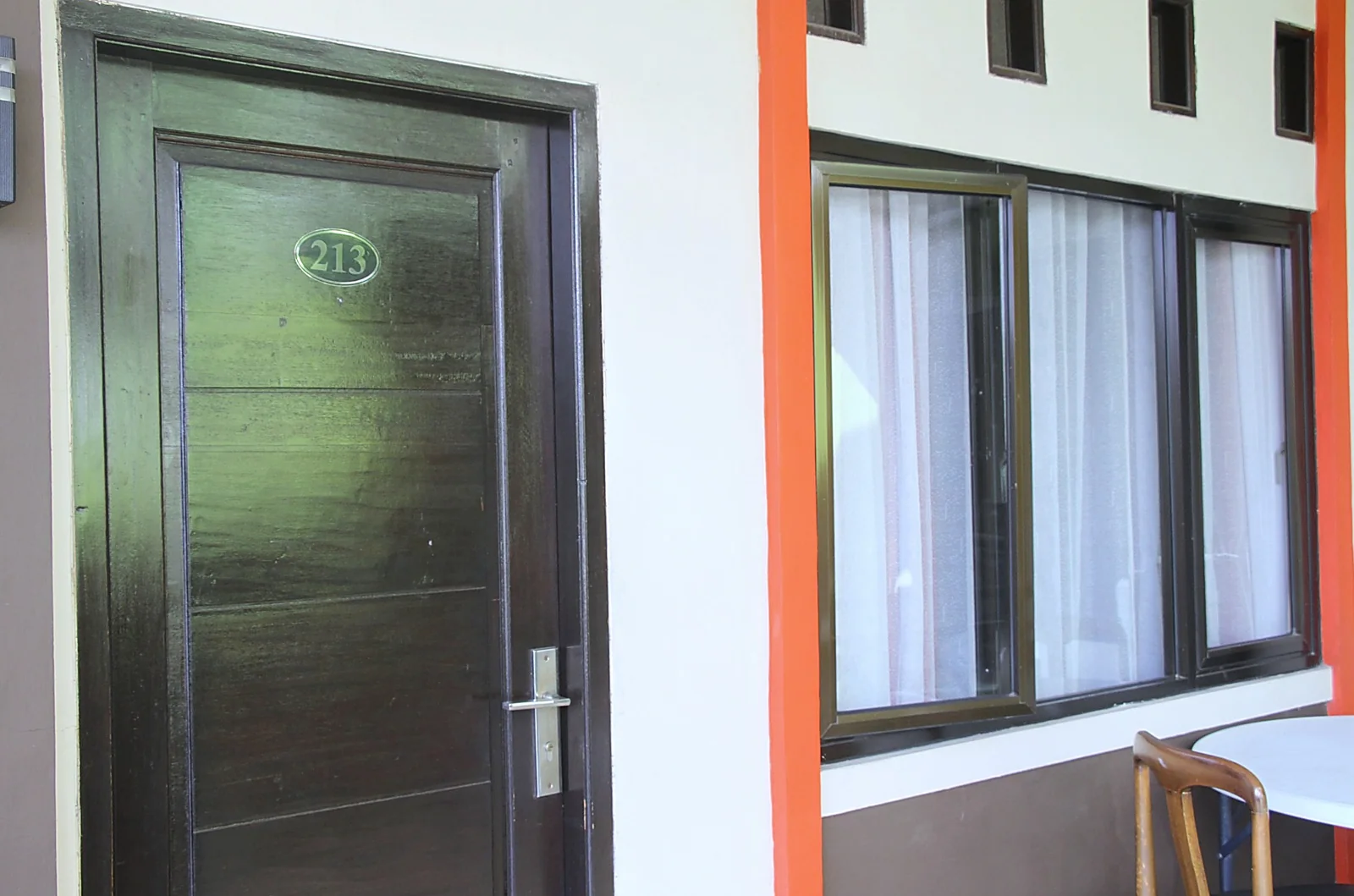 Kamar mandi Superior Room dengan toilet putih, shower, ubin putih, aksen tile hitam putih, dan lantai geometris.
